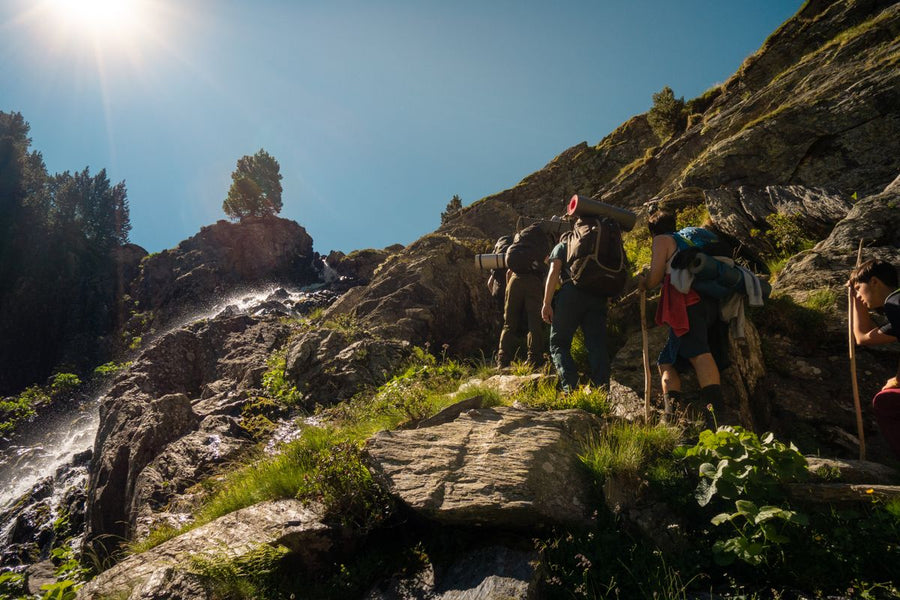 Hikers with backpacks on a rocky mountain path